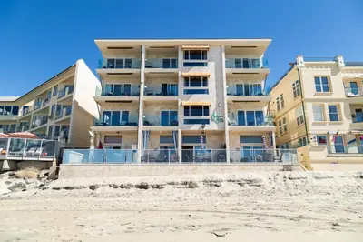 a building on the beach next to the sand at Seashore On The Sand in Carlsbad