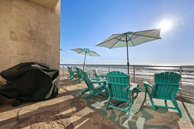a group of chairs and umbrellas on a beach at Seashore On The Sand in Carlsbad