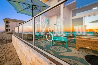 a building with a table and chairs and an umbrella at Seashore On The Sand in Carlsbad