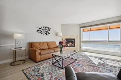 a living room with a couch and a fireplace at Seashore On The Sand in Carlsbad
