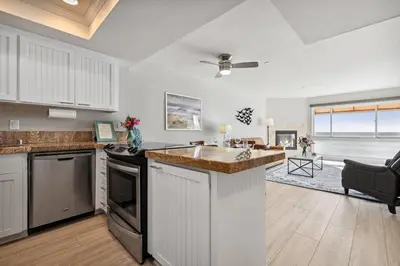 a kitchen with a sink and a living room at Seashore On The Sand in Carlsbad