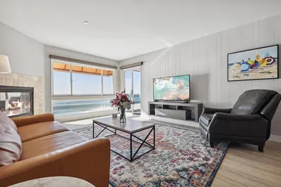 a living room with a couch and a tv at Seashore On The Sand in Carlsbad