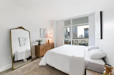 a white bedroom with a large bed and a window at 3BR Downtown Peaceful Corner in San Diego