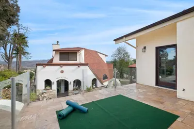 a backyard with a green artificial turf yard in front of a house at Beso De Cielo or Slow Sip of Solitude in Alpine