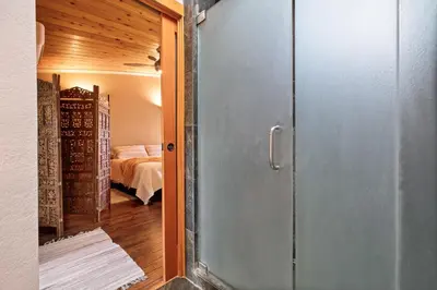 a glass door leading to a bedroom with a bed at Beso De Cielo or Slow Sip of Solitude in Alpine