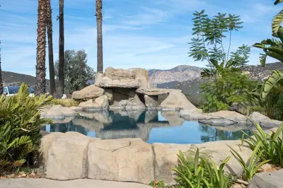 a pool of water with rocks and palm trees at Beso De Cielo or Slow Sip of Solitude in Alpine