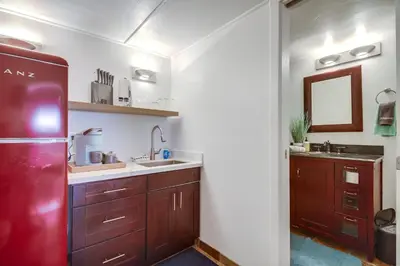 a kitchen with wooden cabinets and a red refrigerator at Coastal SD Retreat Studio Pets Close to Ocean in San Diego