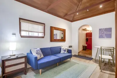 a living room with a blue couch and a table at Coastal SD Retreat Studio Pets Close to Ocean in San Diego
