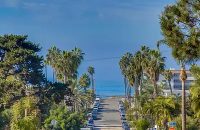 a path leading to the beach with palm trees and the ocean at Coastal SD Retreat Studio Pets Close to Ocean in San Diego