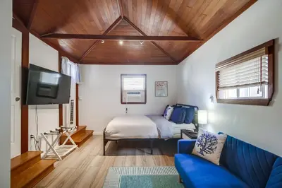 a bedroom with a bed and a tv and a couch at Coastal SD Retreat Studio Pets Close to Ocean in San Diego