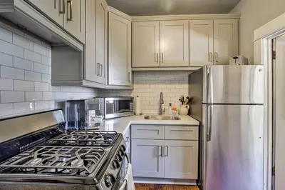 a kitchen with white cabinets and a stainless steel refrigerator at Cozy Apt Near GasLamp in San Diego