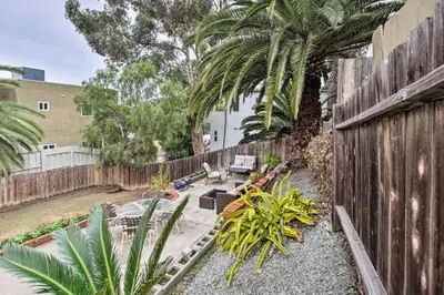 a backyard with a wooden fence and palm trees at Cozy Apt Near GasLamp in San Diego