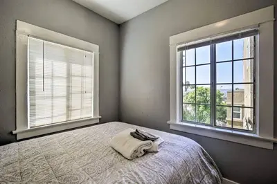 a bedroom with a bed and two windows at Cozy Apt Near GasLamp in San Diego
