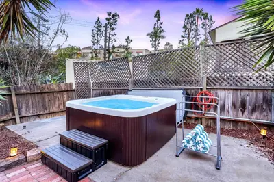 a hot tub in a yard next to a fence at Designer Oasis with Hot Tub Firepit BBQ Sleeps 6 in San Diego