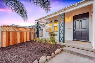 a house with a black door and a fence at Designer Oasis with Hot Tub Firepit BBQ Sleeps 6 in San Diego