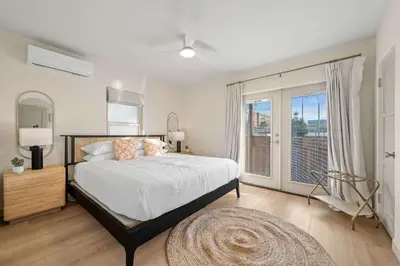 a bedroom with a bed and a large window at Designer Oasis with Hot Tub Firepit BBQ Sleeps 6 in San Diego