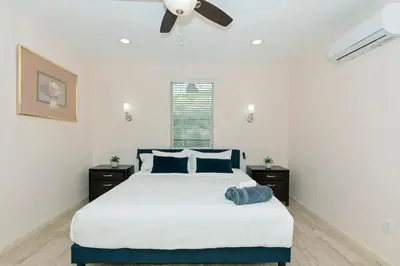 a bedroom with a bed with blue pillows and a ceiling fan at Spacious Single Level Home In Poway in Poway
