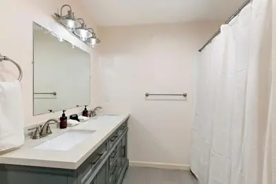 a bathroom with a sink and a shower with a mirror at Spacious Single Level Home In Poway in Poway
