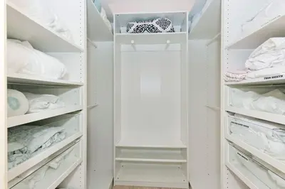 a white walk in closet with white shelves at Spacious Single Level Home In Poway in Poway