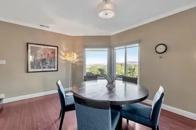 a dining room with a table and chairs and a clock at The Zen House Temecula in Temecula