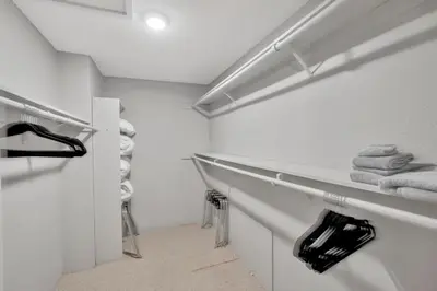 a white bathroom with white towels and a shelf at The Zen House Temecula in Temecula