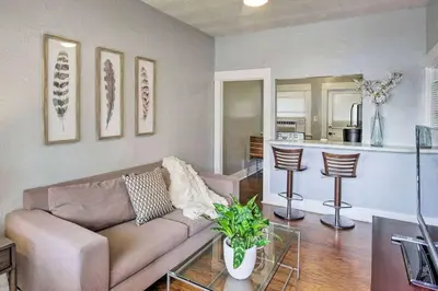 a living room with a couch and a kitchen at Little Italy Apt in San Diego