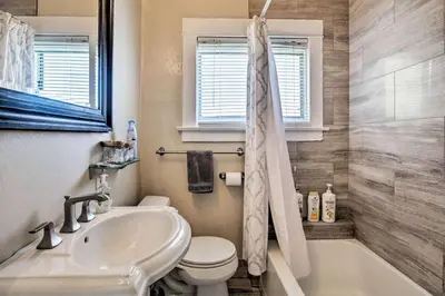a bathroom with a sink and a toilet and a tub at Little Italy Apt in San Diego