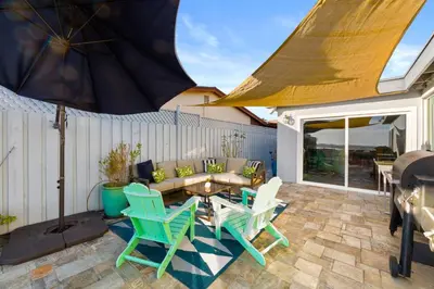 a patio with chairs and a couch and a table at Bayside Bliss House - Pool Spa Views in San Diego