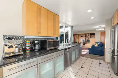 a kitchen with wooden cabinets and stainless steel appliances at Bayside Bliss House - Pool Spa Views in San Diego