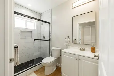 a white bathroom with a toilet and a sink at Cozy Casa | Sleek & Modern Monthly Escape in Santee
