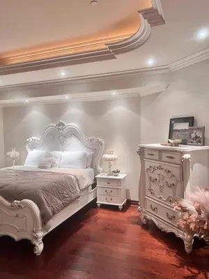 a bedroom with a white bed and a dresser at The Chateau Escondido in Escondido