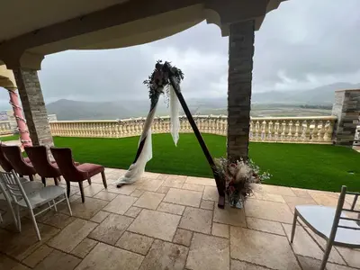 a porch with a wedding arch with chairs and flowers at The Chateau Escondido in Escondido