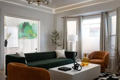 a living room with a green couch and a table at Luxe Victorian Retreat • Walk to Downtown in San Diego