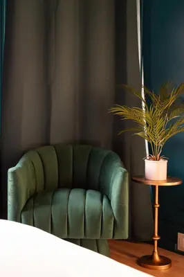 a green chair in a room with a potted plant at Luxe Victorian Retreat • Walk to Downtown in San Diego