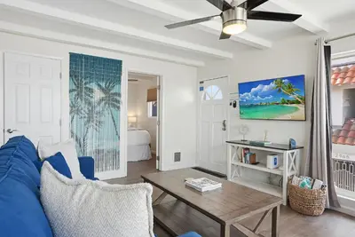 a living room with a blue couch and a table at Oceanview Mission Beach Compound, Balcony, Patio, Fire Pit, BBQ, Steps to Sand in San Diego