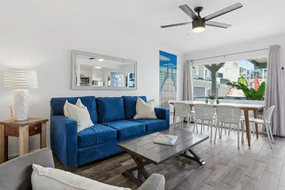a living room with a blue couch and a table at Oceanview Mission Beach Compound, Balcony, Patio, Fire Pit, BBQ, Steps to Sand in San Diego