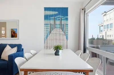 a dining room with a white table and chairs at Oceanview Mission Beach Compound, Balcony, Patio, Fire Pit, BBQ, Steps to Sand in San Diego