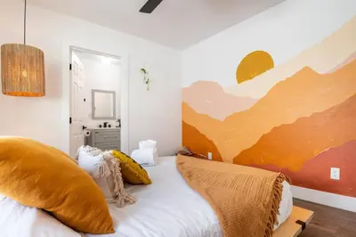 a bedroom with a bed with a painting on the wall at Artist micro-villa with kitchen, firepit & theater in San Diego