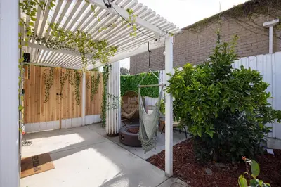 a patio with a white pergola and some plants at Artist micro-villa with kitchen, firepit & theater in San Diego