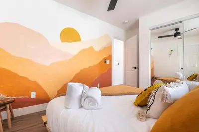 a bedroom with two beds and a painting on the wall at Artist micro-villa with kitchen, firepit & theater in San Diego