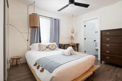 a bedroom with a large bed and a dresser at Artist micro-villa with kitchen, firepit & theater in San Diego