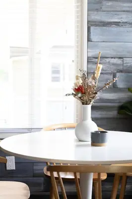 a white table with a vase of flowers on it at SoCal Living w/ Pool, hot tub and movie theater in San Diego