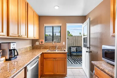 a kitchen with a sink and a door to a patio at Point Loma Hideaway Relaxing Hot Tub & AC in San Diego