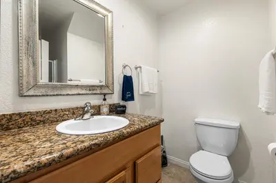 a bathroom with a sink and a toilet and a mirror at Point Loma Hideaway Relaxing Hot Tub & AC in San Diego