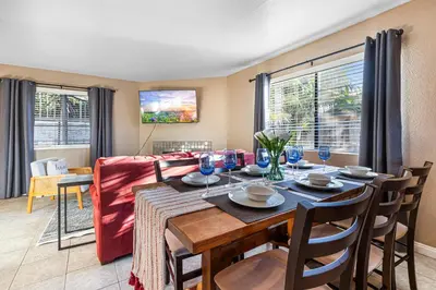 a dining room with a table and chairs and a couch at Point Loma Hideaway Relaxing Hot Tub & AC in San Diego