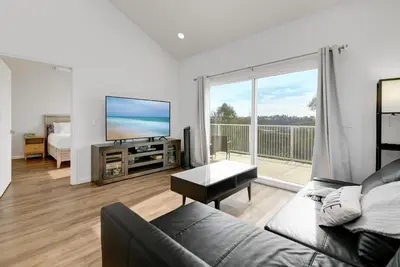 a living room with a couch and a flat screen tv at Bright Spacious Modern Getaway in San Diego