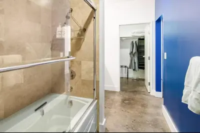 a bathroom with a tub and a glass shower at Historic Gaslamp Loft with Peloton Bike and Roof Deck in San Diego