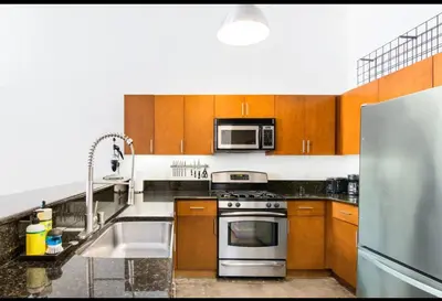 a kitchen with a stainless steel stove and a microwave at Historic Gaslamp Loft with Peloton Bike and Roof Deck in San Diego