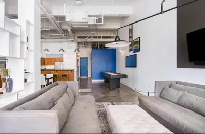 a living room with a couch and a table at Historic Gaslamp Loft with Peloton Bike and Roof Deck in San Diego