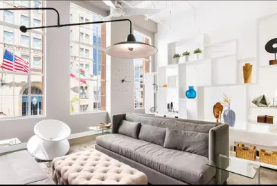 a living room with a couch and some windows at Historic Gaslamp Loft with Peloton Bike and Roof Deck in San Diego
